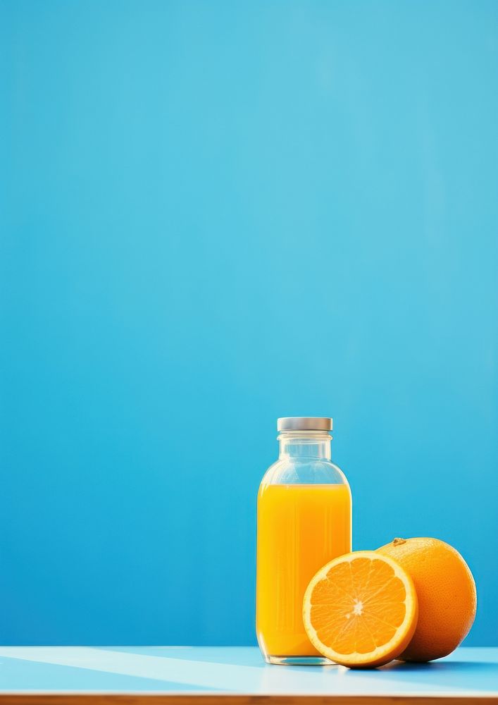 A blue bottle sitting on top of a table next to oranges juice fruit drink. AI generated Image by rawpixel.
