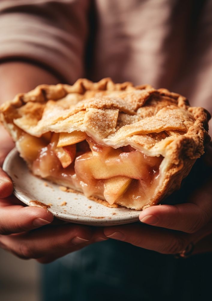 A person holding piece of apple pie dessert food breakfast.