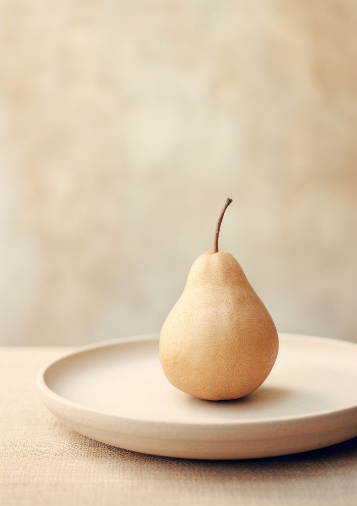 A plate with a pear on a table fruit plant food.
