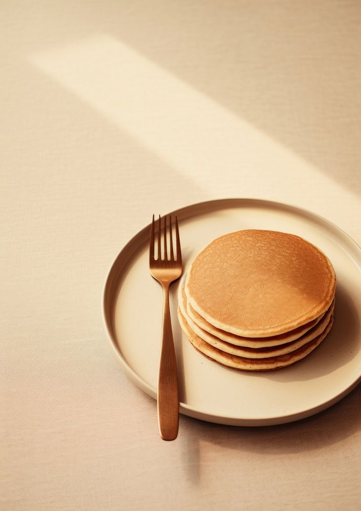 A plate with a fork and a pancakes on a table food silverware simplicity.