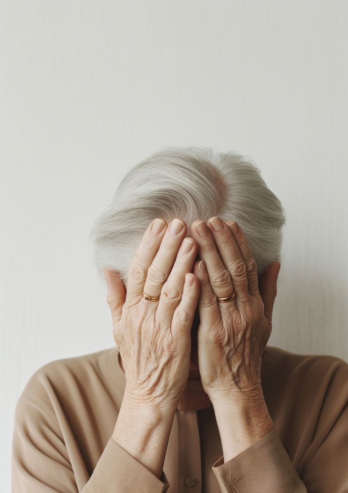 A elderly woman holding her hand to her face photography portrait adult.