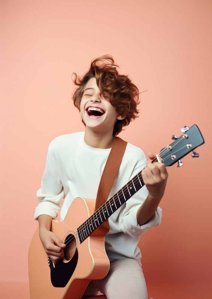 Boy play guitar laughing musician portrait. AI generated Image by rawpixel.