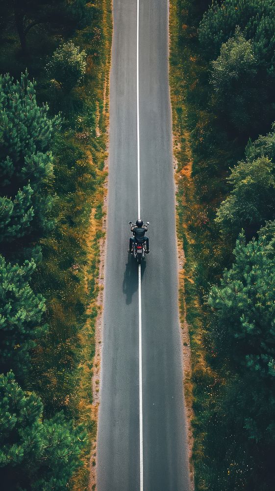 Aerial top down view of motorcycle driving in country road landscape outdoors vehicle.