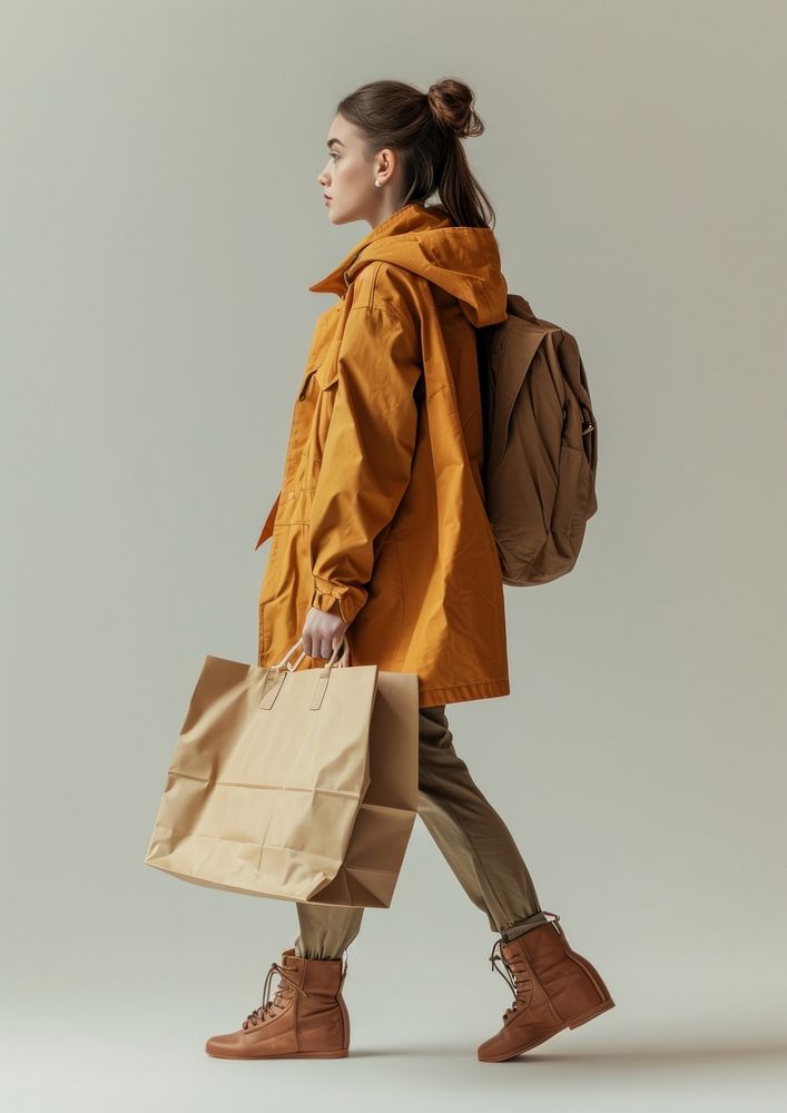 Photo of woman wearing casual outfit bag overcoat walking.