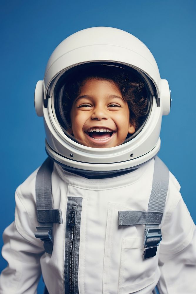 Latinx boy wearing white astronaut suit helmet happy baby.
