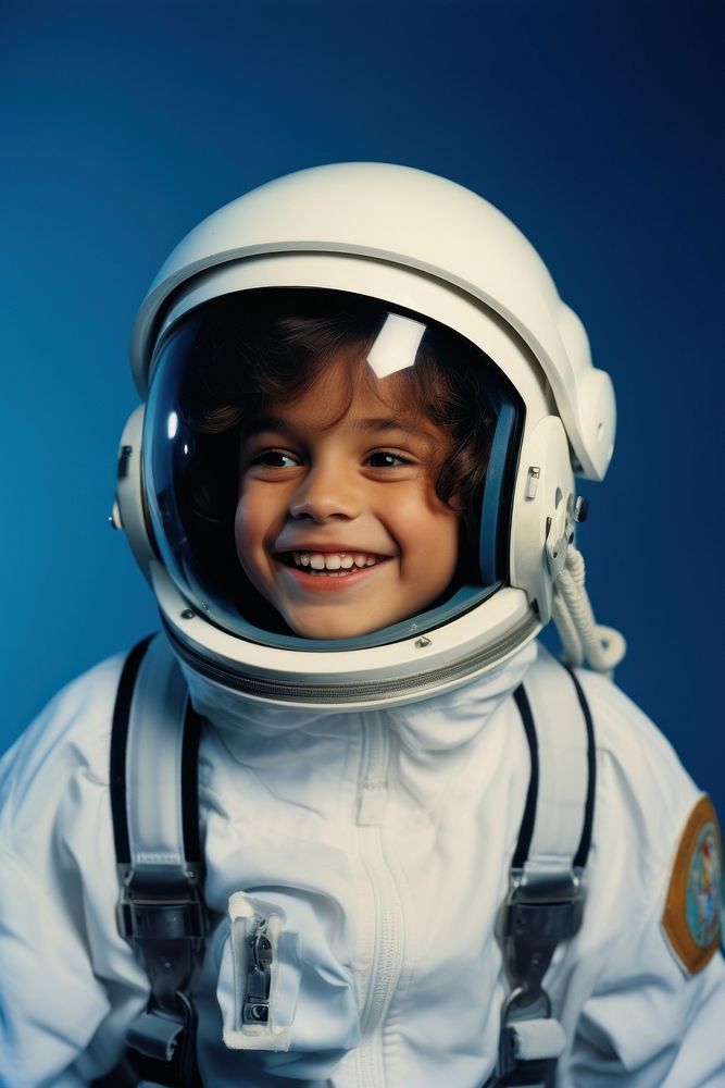 Latinx boy wearing white astronaut suit helmet protection happiness.