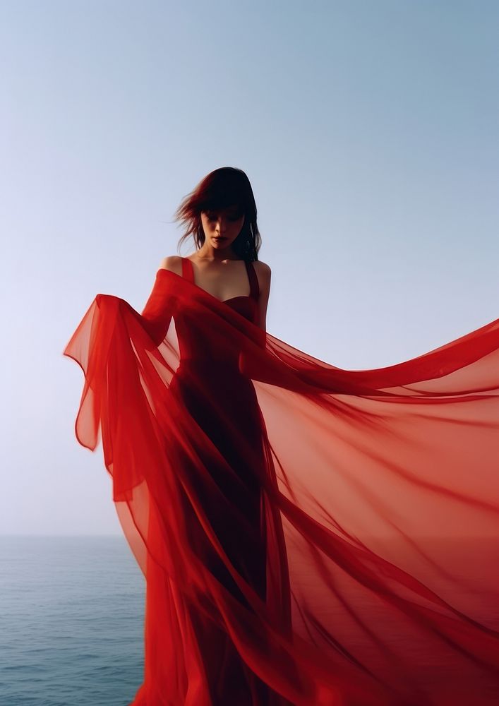 A woman in red dress with red transparent fabric fashion adult gown.