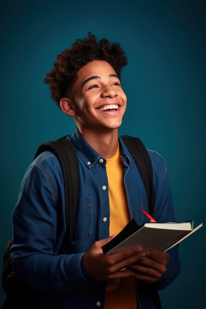 Student holding a book and pencil looking smile publication.