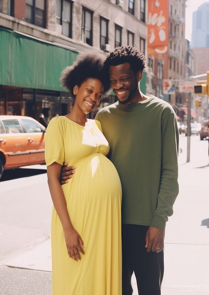 Black man holding hand pregnant woman street portrait family.