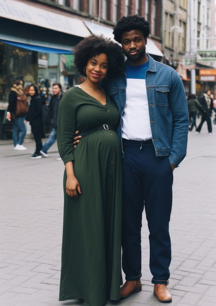 Black man holding hand pregnant black woman footwear portrait street.