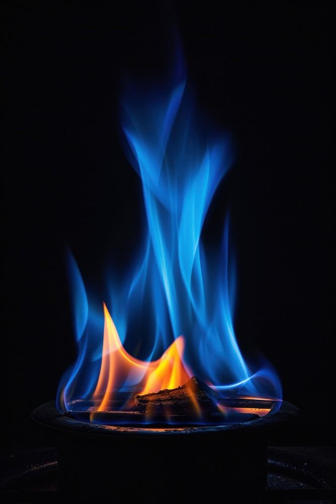 Real blue flame fire black stove black background.