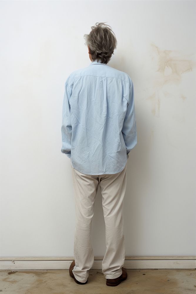 A man in jeans looking up on a white background isolation back view standing sleeve adult.