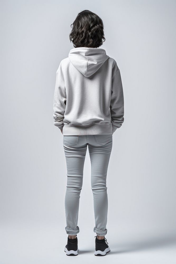 A old woman in jeans looking up on a white background isolation back view sweatshirt adult hood.