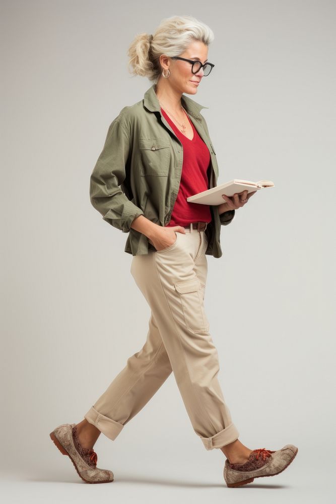 A woman reading newspaper walking footwear adult khaki.