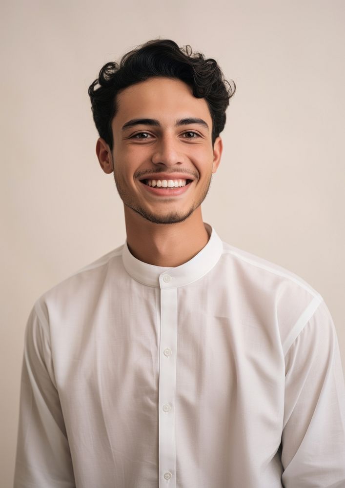 Middle eastern teen man in thawb smiling adult shirt.