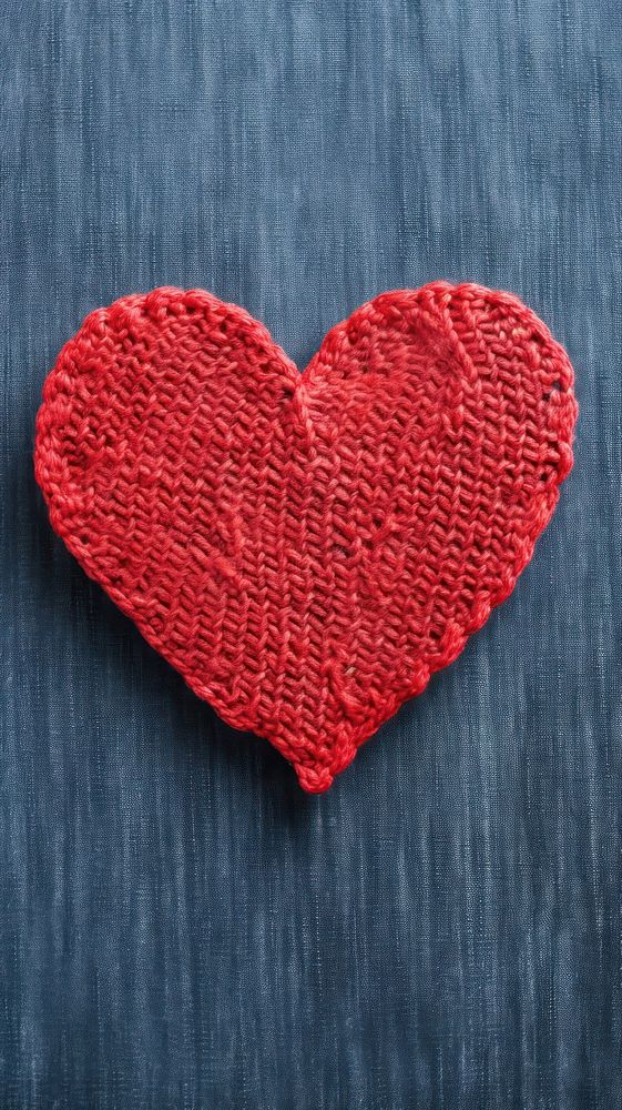  Red knit heart on denim fabric texture creativity textured clothing. AI generated Image by rawpixel.