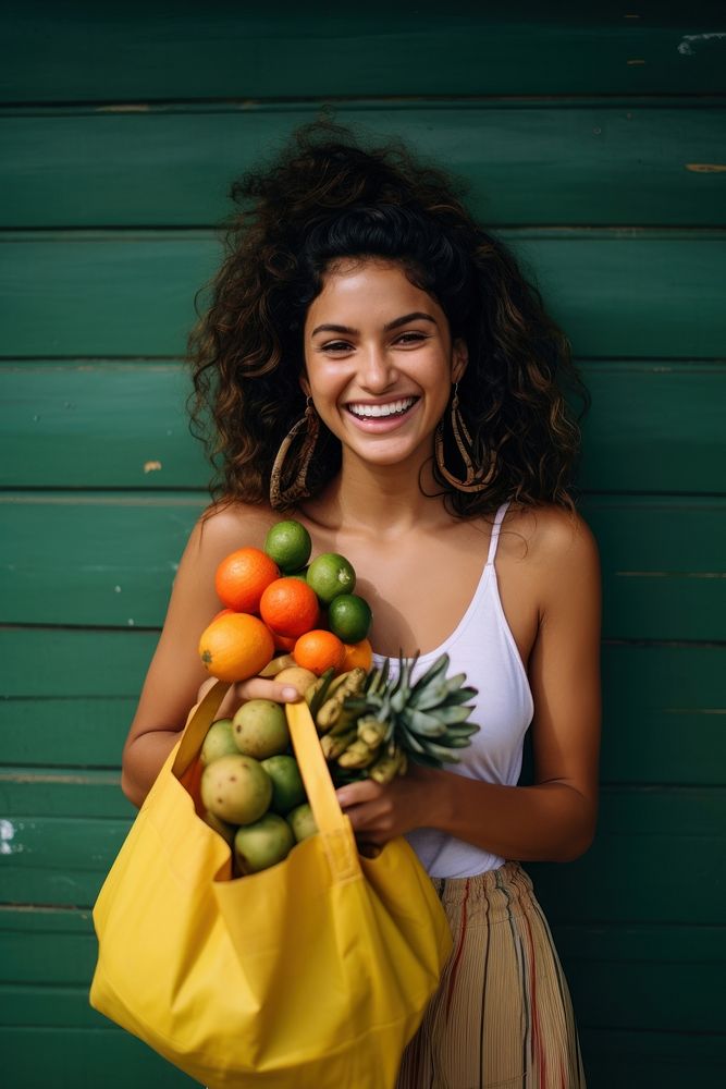 A joyful young Cuban woman holding a bag full of fruits and vegetable pineapple smile adult.