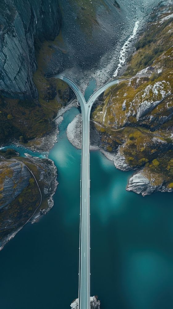 Aerial top down view of stunning bridge against mountain landscape outdoors road.