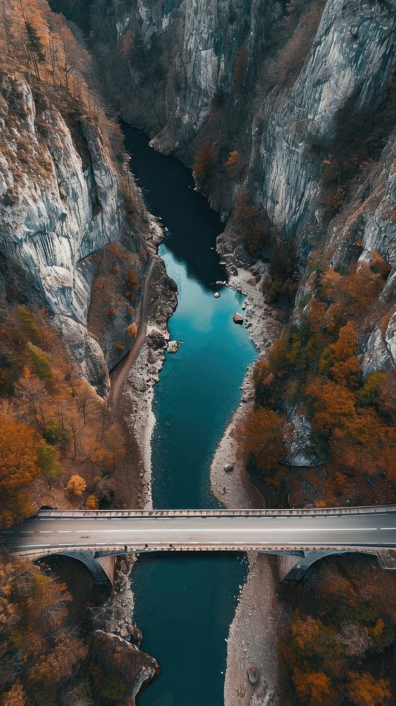 Aerial top down view of stunning bridge against mountain landscape outdoors nature.