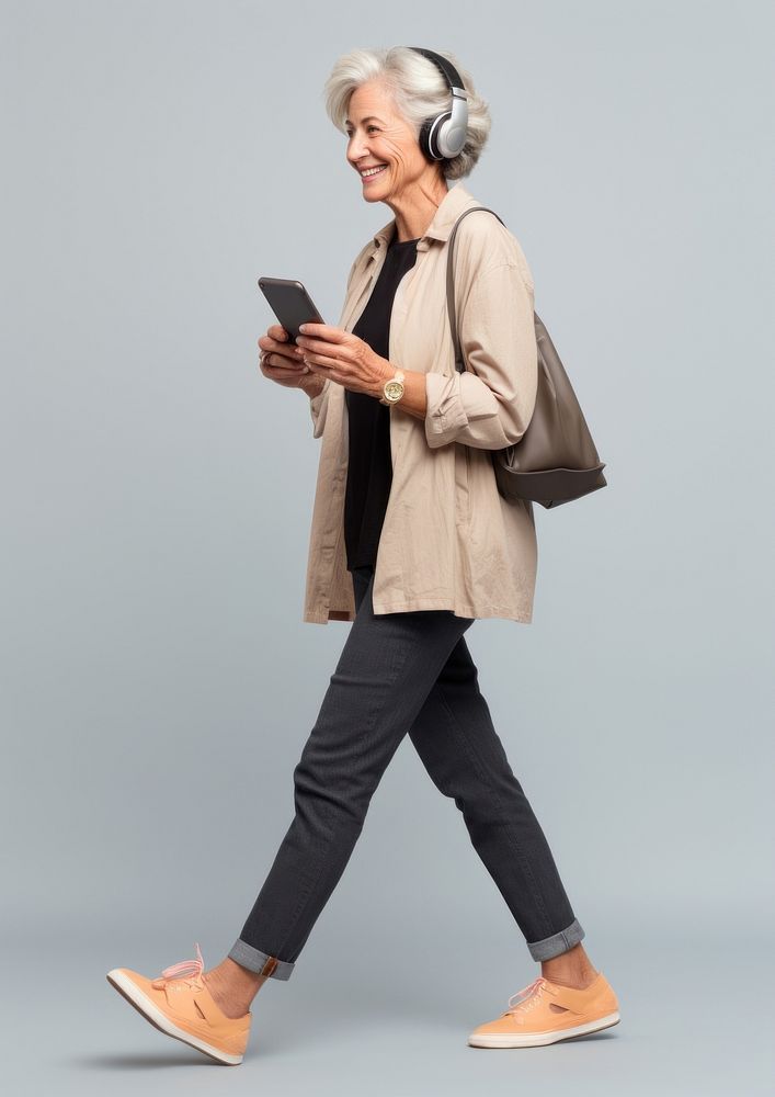 A senior woman with mobile phone walking headphones footwear. AI generated Image by rawpixel.