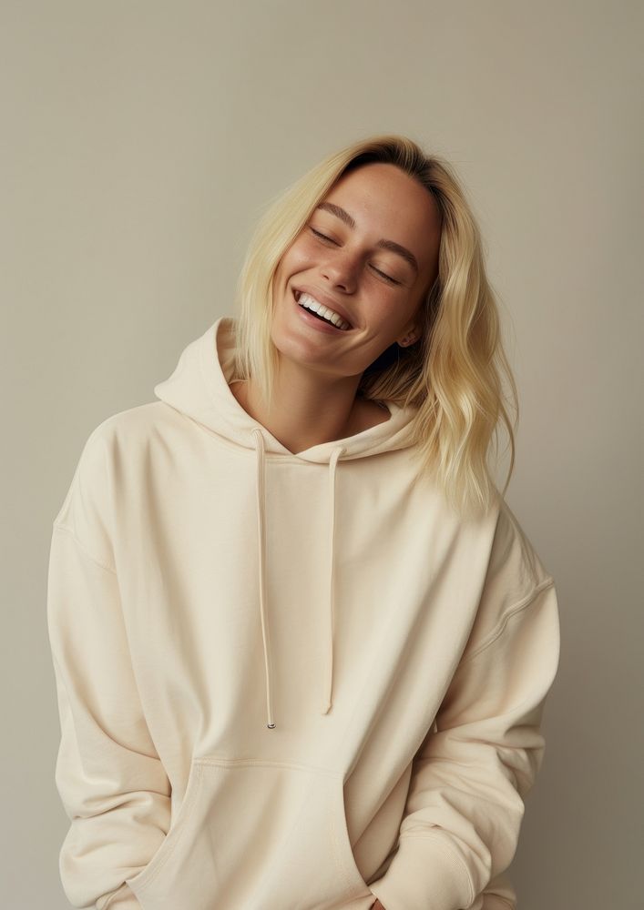 A happy british woman wear cream hoodie sweatshirt laughing sweater.