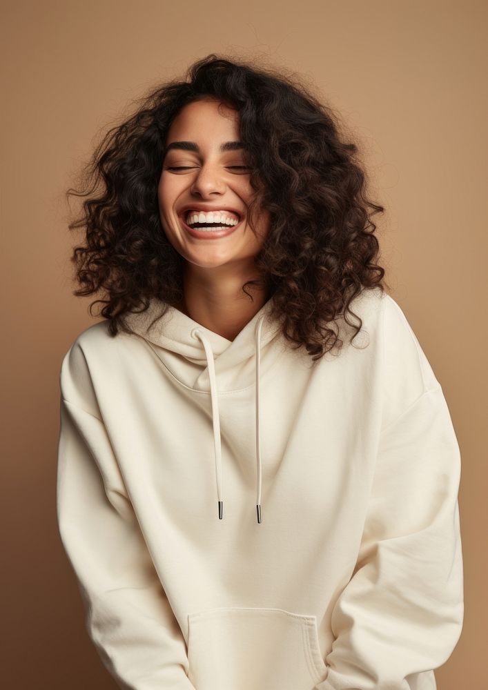 A happy hispanic woman wear cream hoodie sweatshirt laughing fashion.