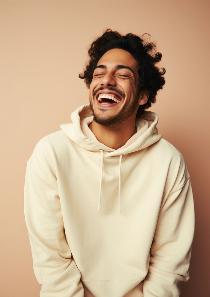A happy hispanic man wear cream hoodie sweatshirt laughing relaxation.