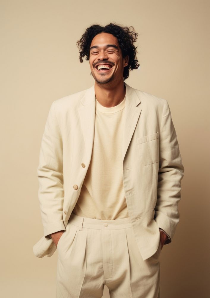A happy mixed race british man wear cream casual suit laughing fashion blazer.