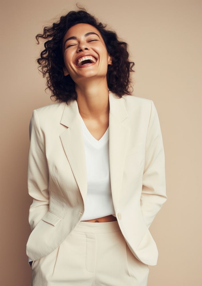A happy mixed race british woman wear cream casual suit laughing fashion smile.