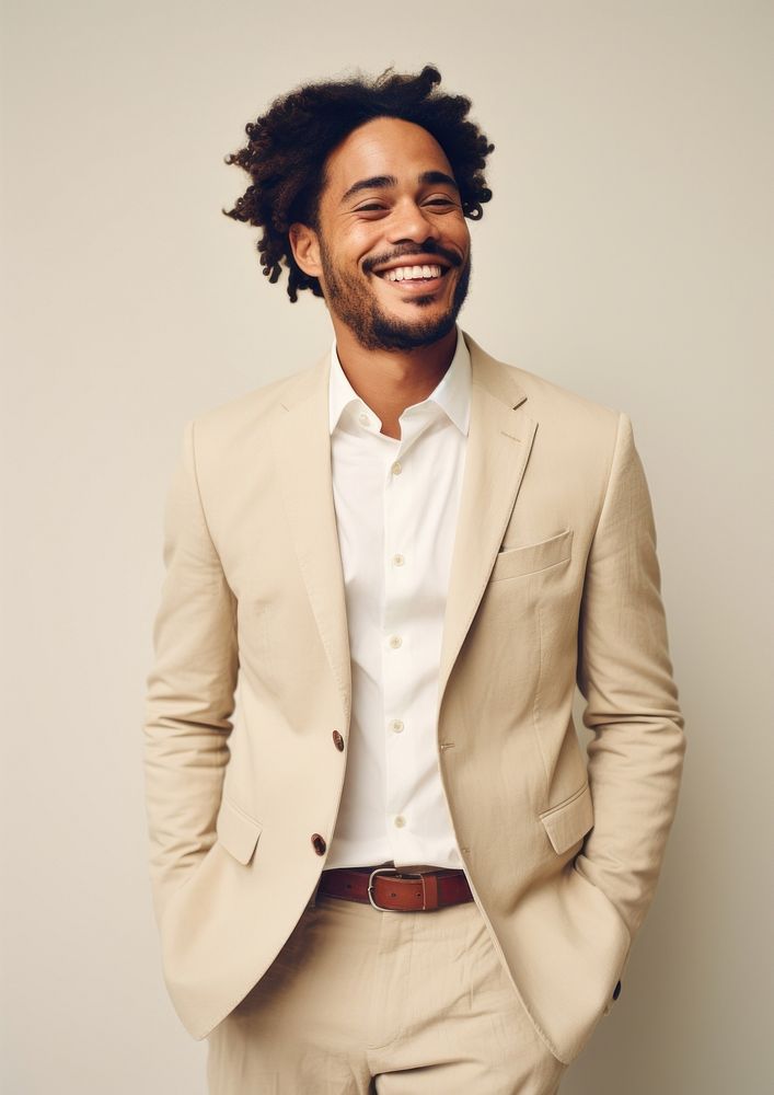 A happy mixed race british man wear cream casual suit laughing fashion blazer.