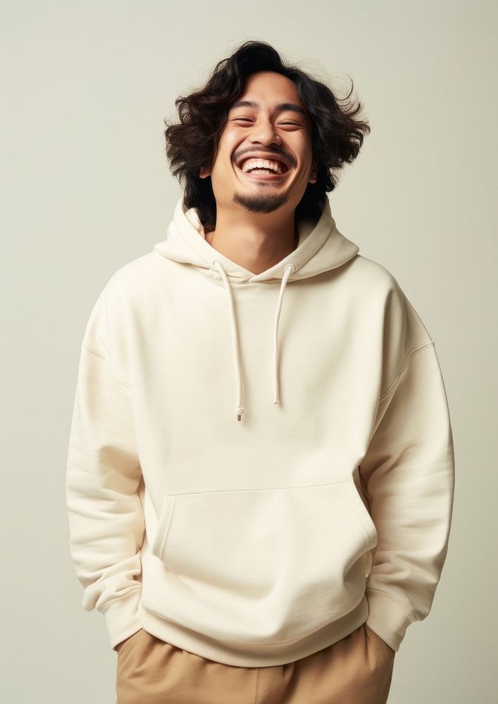 A happy mixed race japanese man wear cream hoodie sweatshirt laughing fashion.