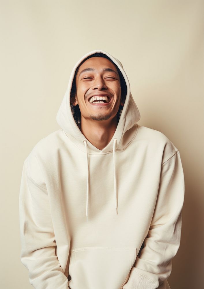 A happy mixed race japanese man wear cream hoodie sweatshirt laughing smile.