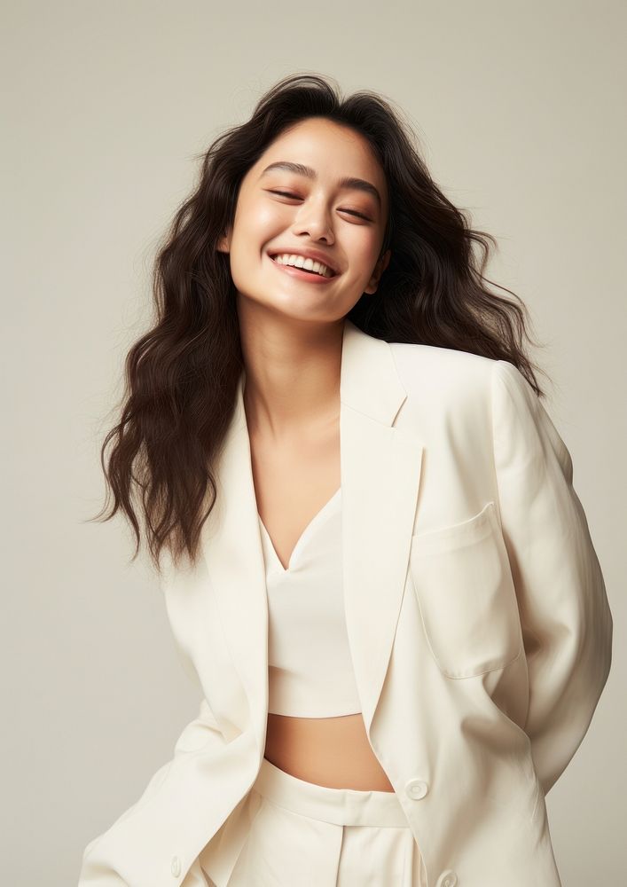 A happy mixed race japanese woman wear cream casual suit laughing fashion smile.