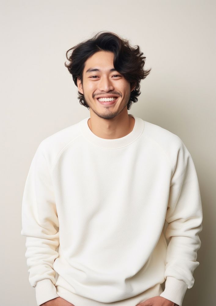 A happy mixed race japanese man wear cream sweater laughing smile adult.