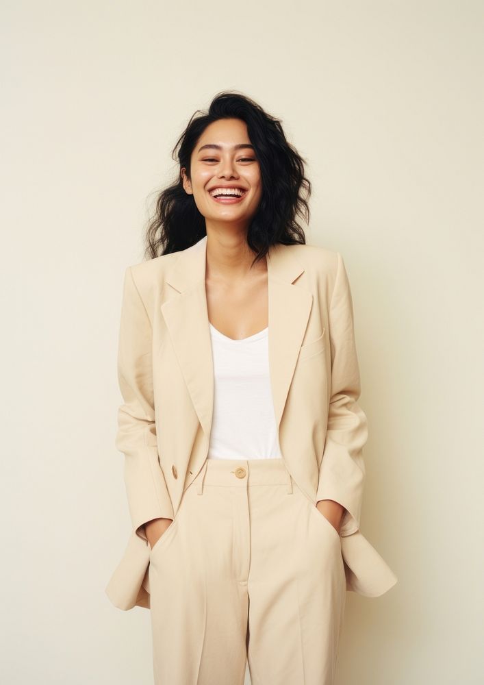A happy mixed race japanese woman wear cream casual suit laughing fashion blazer.