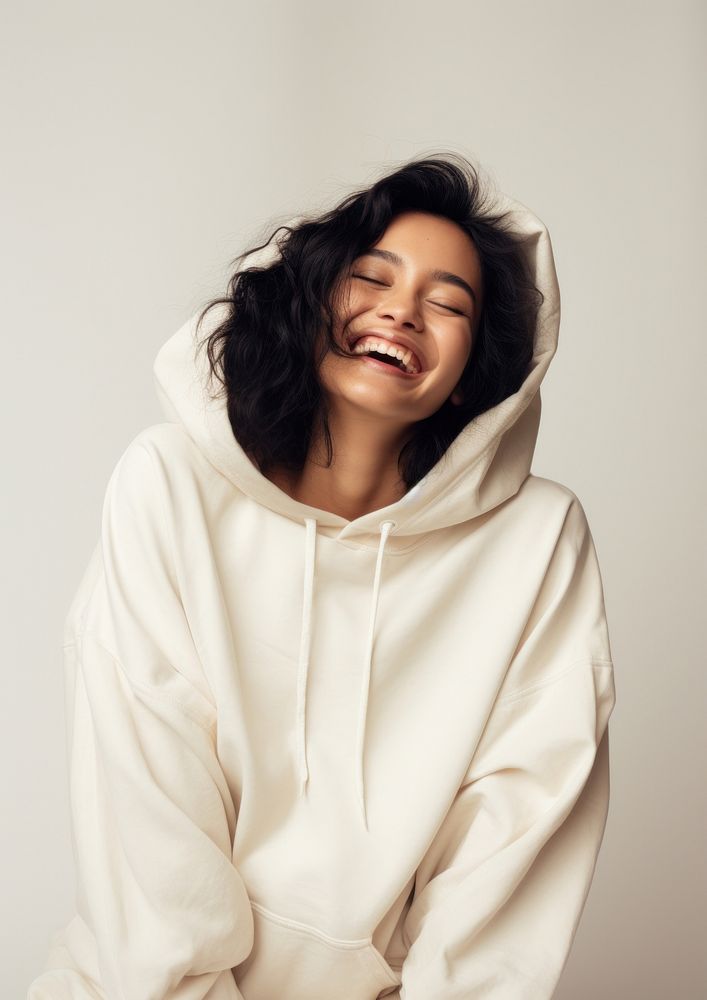 A happy mixed race japanese woman wear cream hoodie sweatshirt laughing fashion.
