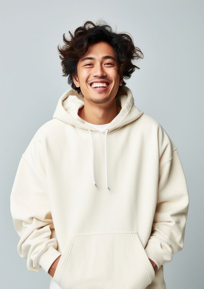 A happy mixed race japanese man wear cream hoodie sweatshirt laughing sweater.