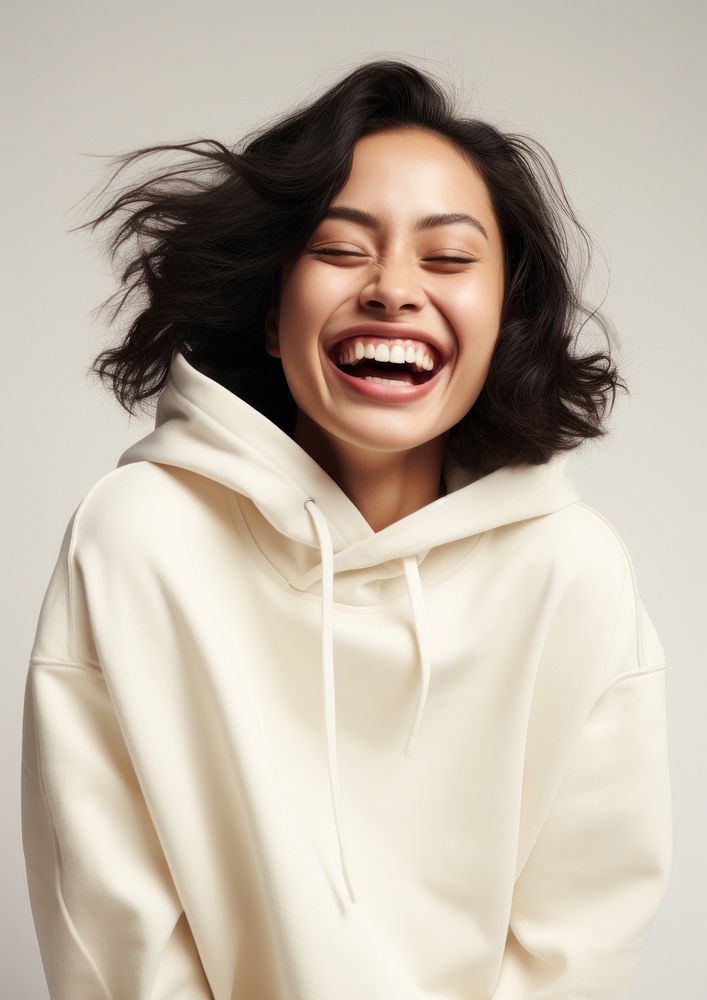 A happy mixed race japanese woman wear cream hoodie laughing fashion relaxation.