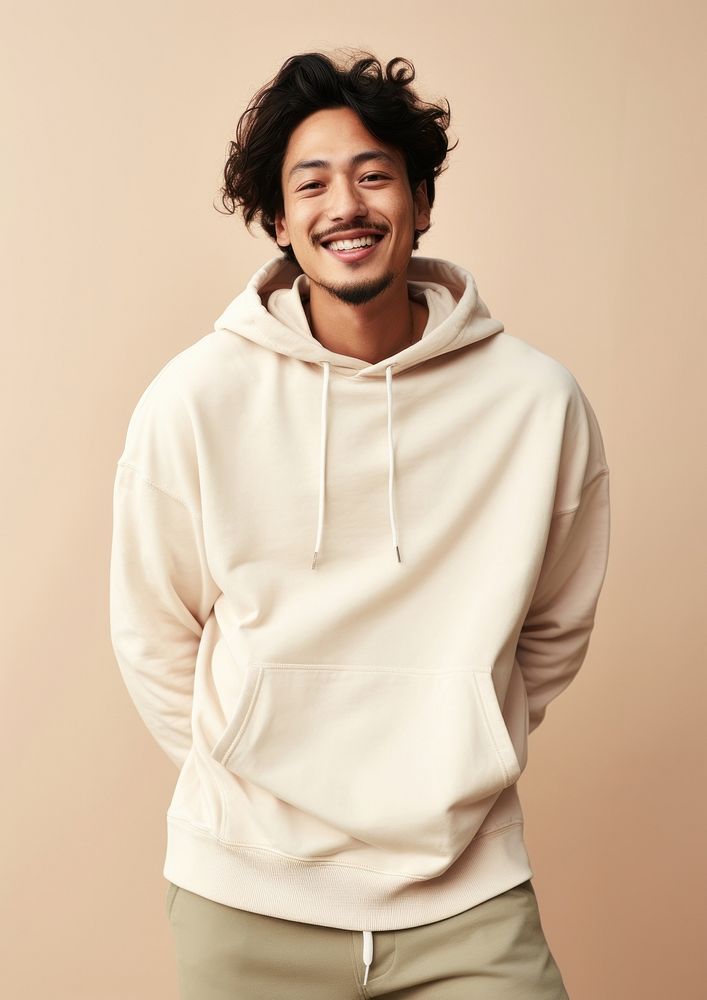 A happy mixed race korean man wear cream hoodie sweatshirt sweater smile.