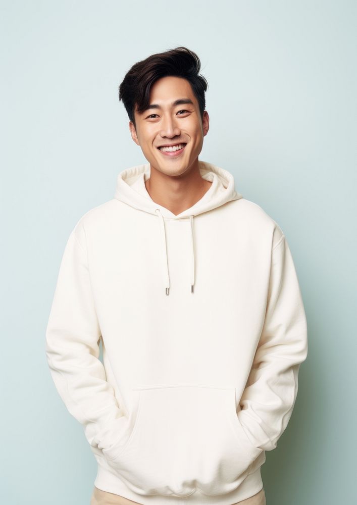 A happy mixed race korean man wear cream hoodie sweatshirt smile architecture.