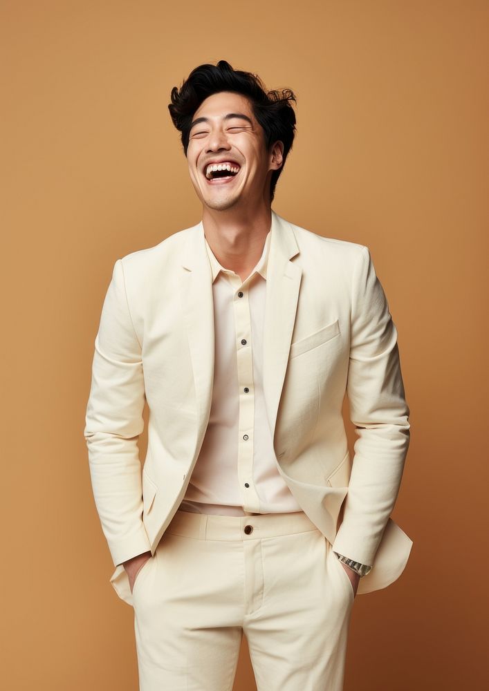 A happy mixed race korean man wear cream casual suit laughing fashion smile.