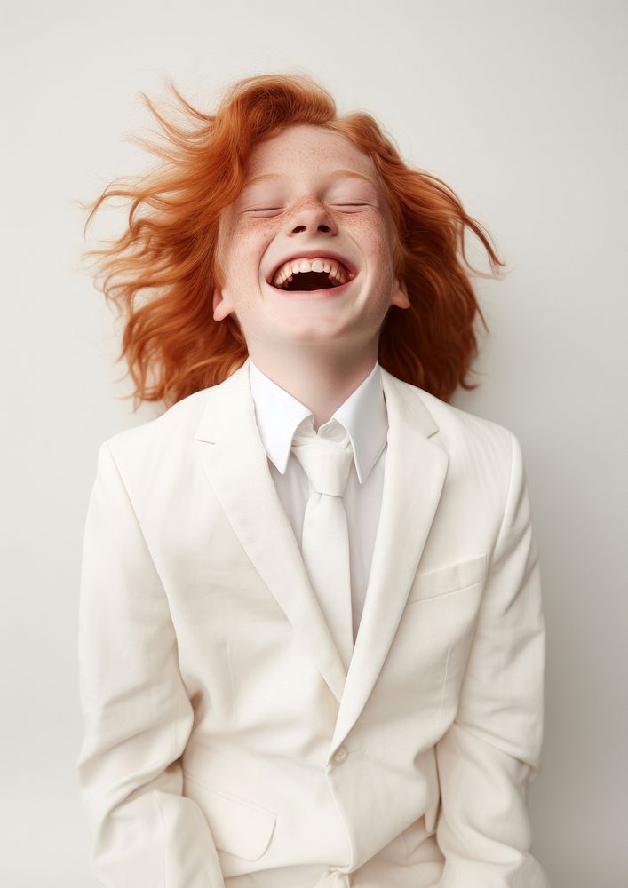 A happy red hair kid wear cream casual suit laughing fashion accessories.