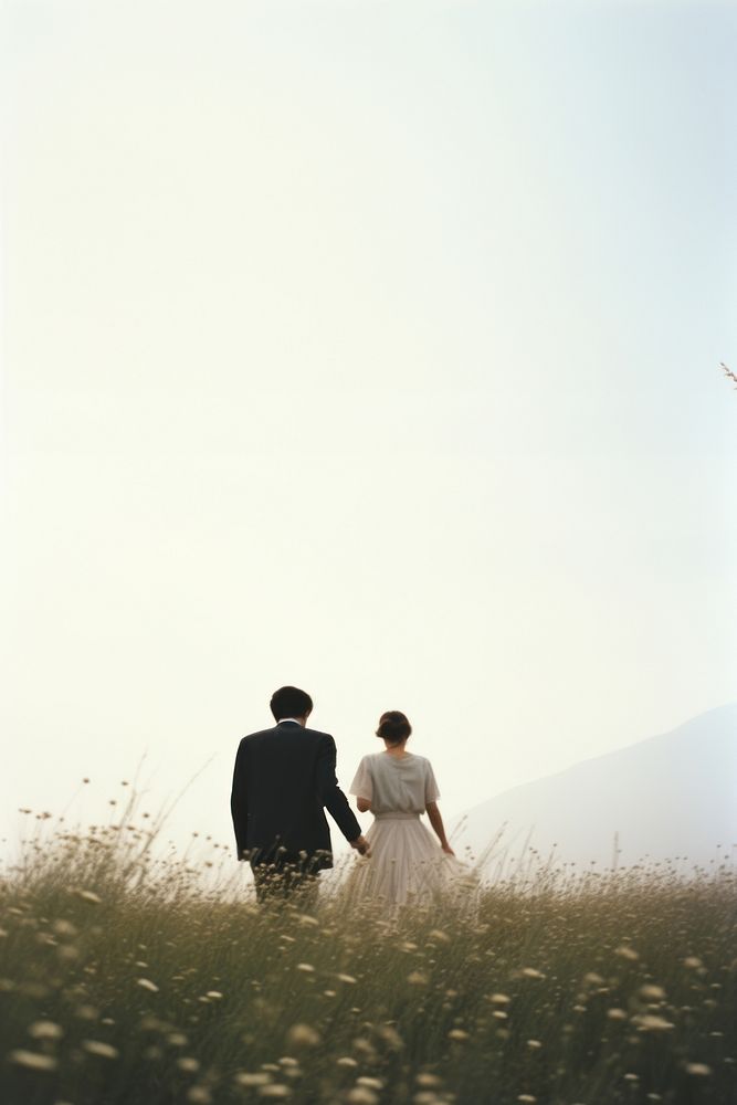 A couple in wedding event photography outdoors walking.