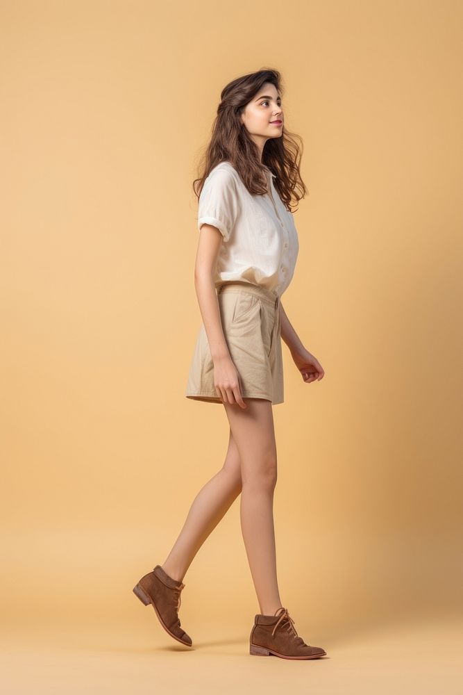 A teenager girl walking in studio miniskirt footwear dress.