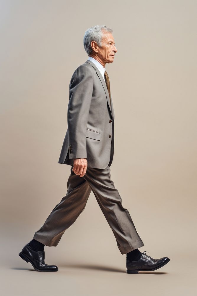A senior man walking in studio wearing suit footwear portrait tuxedo.