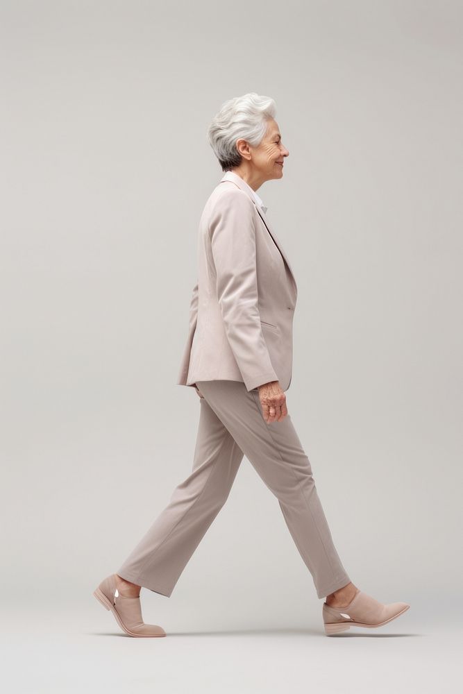 A senior woman walking in studio adult suit side view.
