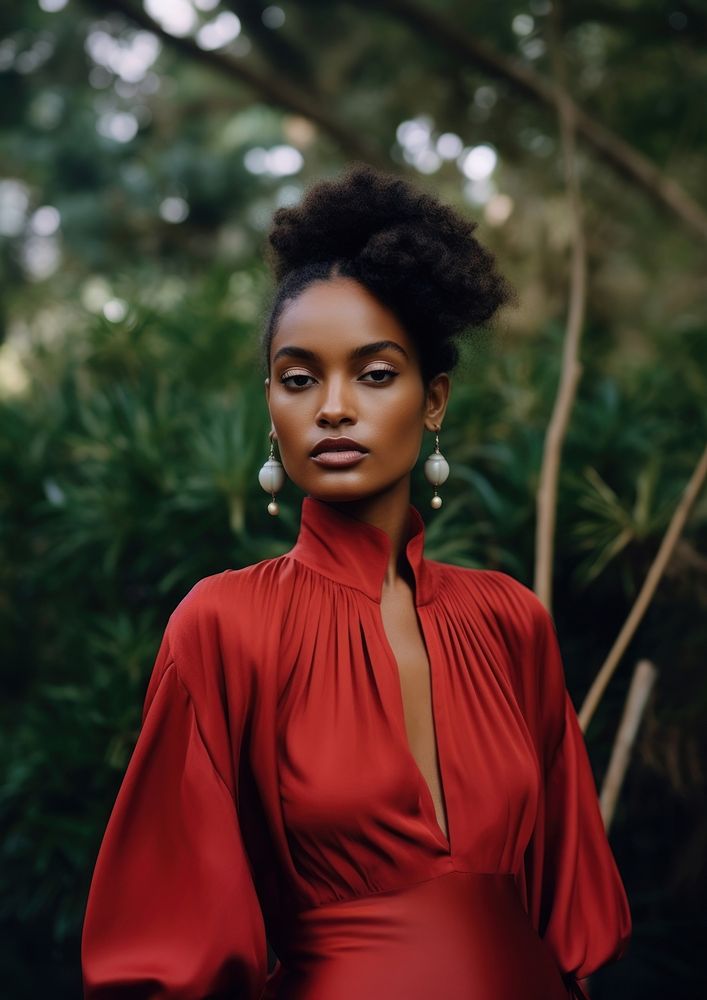 A black woman wearing red shirt with pearl earring photography portrait fashion.