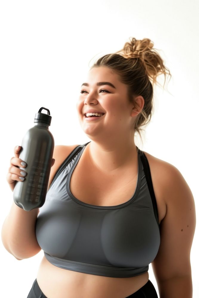 A chubby woman holding water bottle and smiling and looking up while exercising portrait adult photo.