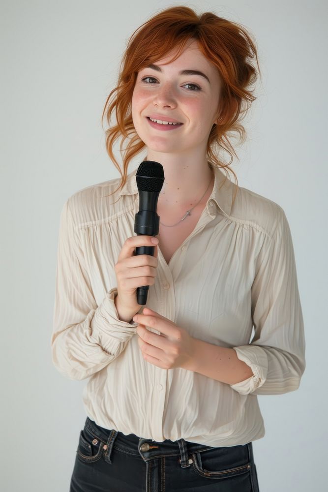 A woman lecturer holding a microphone at chest level portrait clothing smiling.