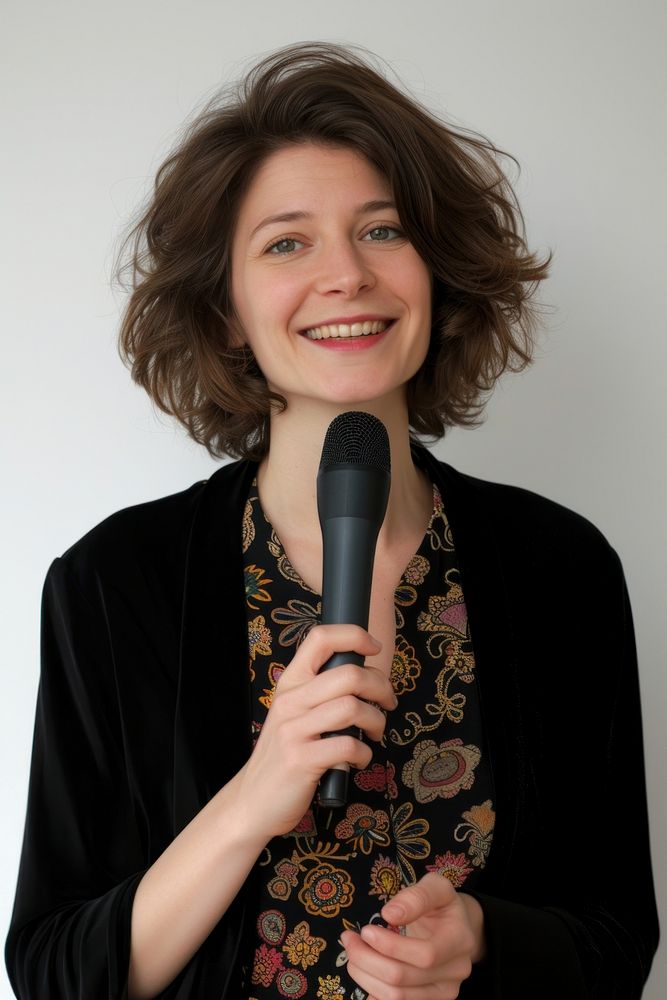 A woman lecturer holding a microphone portrait smiling adult.